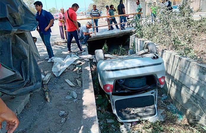 Joven vuelca su automóvil en un dren pluvial