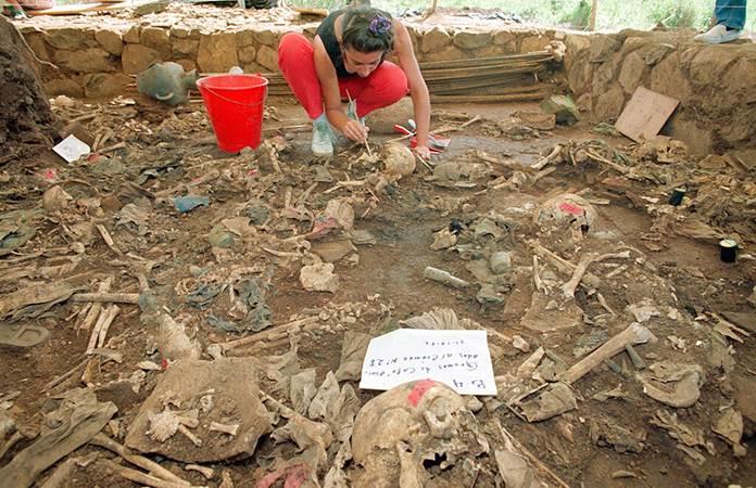 Una antropóloga forense limpia restos humanos en El Salvador / Foto: archivo AP