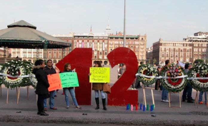 Familiares de víctimas del News Divine colocan antimonumento en el Zócalo capitalino