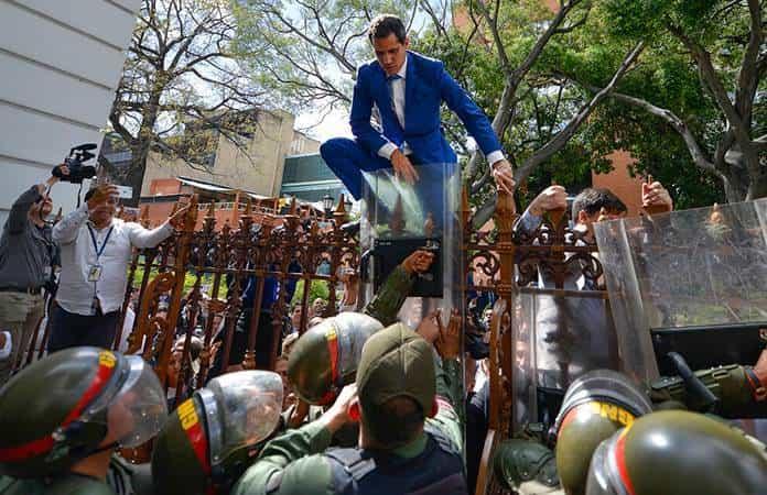 Juan Guaidó trepa una valla en un intento fallido por ingresar a la Asamblea Nacional / Foto: AP