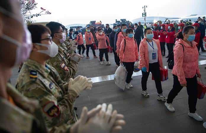 Elementos de seguridad aplauden al personal médico que se marcha de Wuhan / Foto: AP