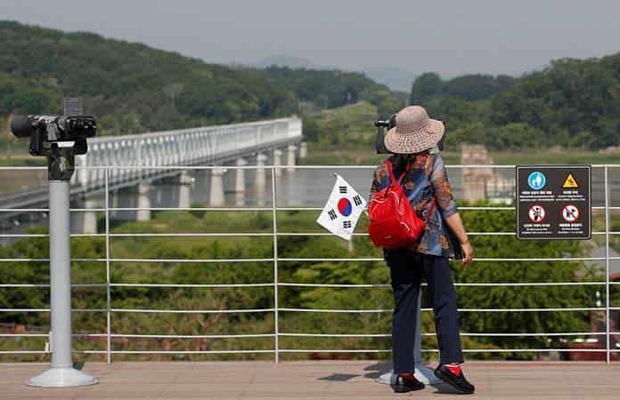 Una turista surcoreana utiliza los prismáticos para ver hacia Corea del Norte / Foto: AP