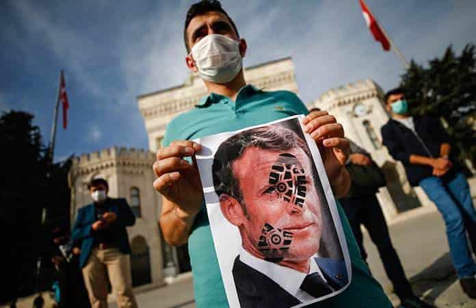 Un joven sostiene una fotografía de Macron durante una protesta contra Francia en Estambul / Foto: AP