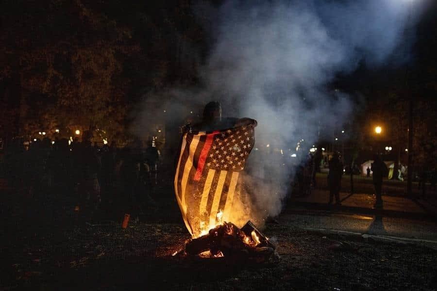 Manifestantes quemaron ayer una bandera en Oregon. Foto: EFE