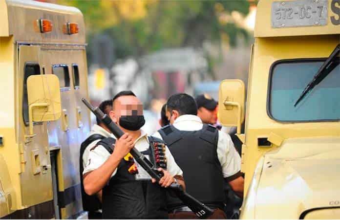 Fotografías de la agencia Cuartoscuro muestran que la camioneta de valores y el cuerpo del hombre fueron resguardados por policías