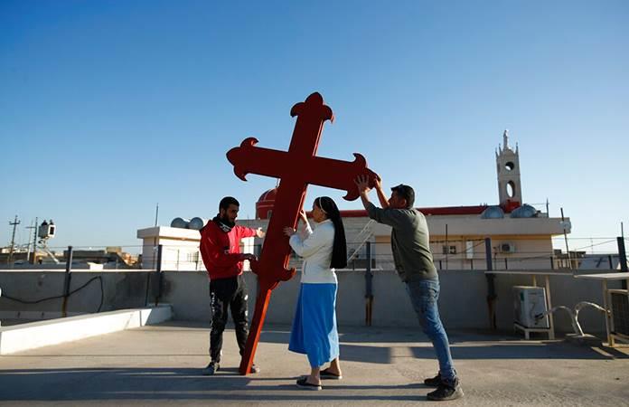 Cristianos iraquíes colocan una cruz en una iglesia en Qaraqosh, Irak / Foto: AP