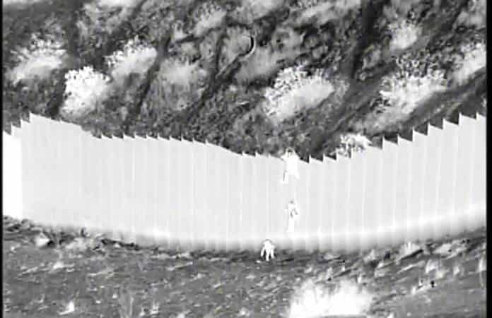 La imagen tomada de un video con visión nocturna muestra a un traficante dejando caer a las niñas  / Foto: AP