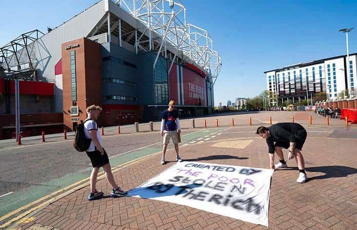 Aficionados del Manchester United colocan una pancarta de protesta frente al estadio Old Trafford / Foto: AP