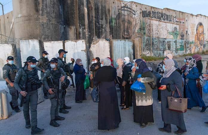 Mujeres palestinas esperan en un puesto de control israelí / Foto: AP