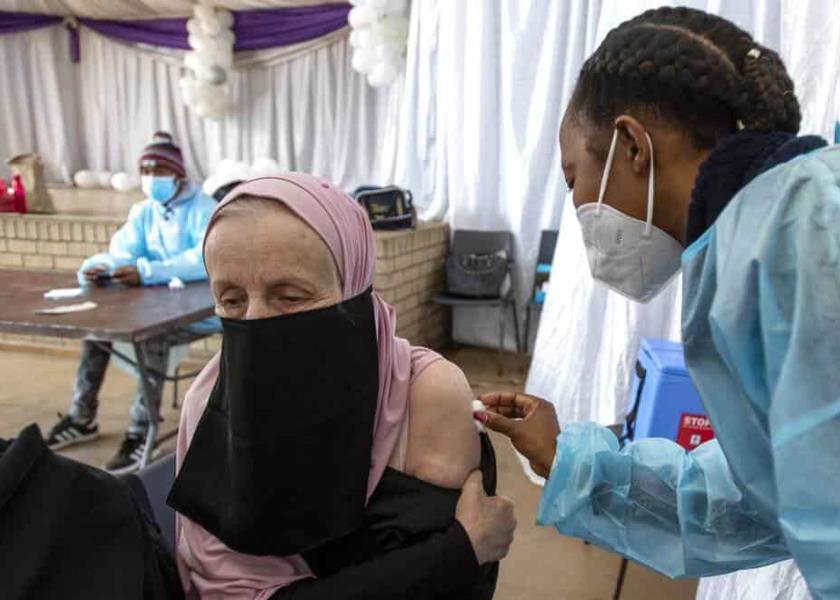 Una profesora recibe la vacuna de Johnson & Johnson contra COVID-19 de manos de una trabajadora de salud en el Centro Cívico de Roshnee, al sur de Johannesburgo, Sudáfrica. (AP Foto/Themba Hadebe)