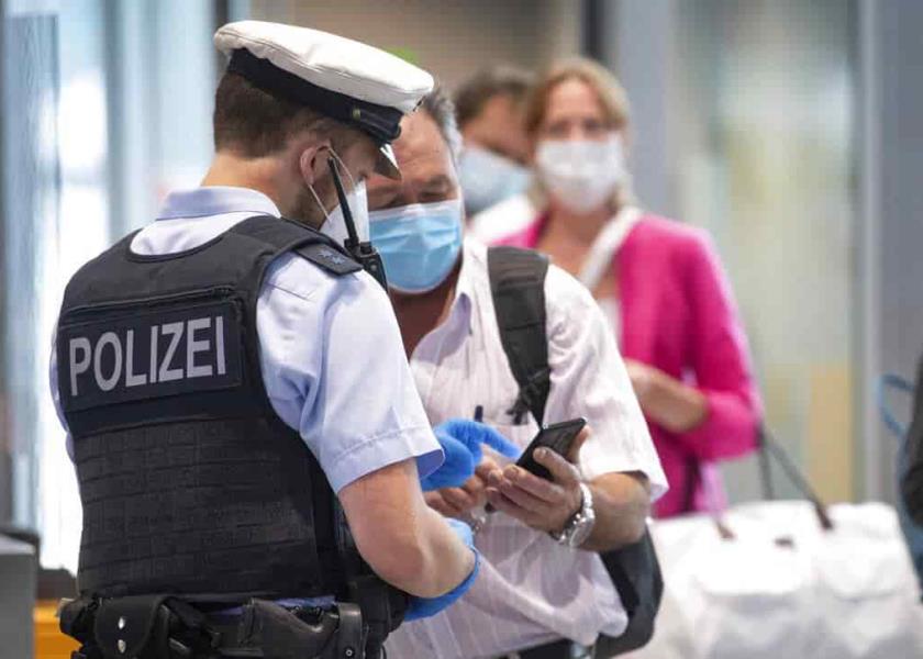 Un agente de la policía federal revisa a pasajeros de un vuelo procedente de Portugal, en el aeropuerto de Fráncfort. (Boris Roessler/dpa vía AP)