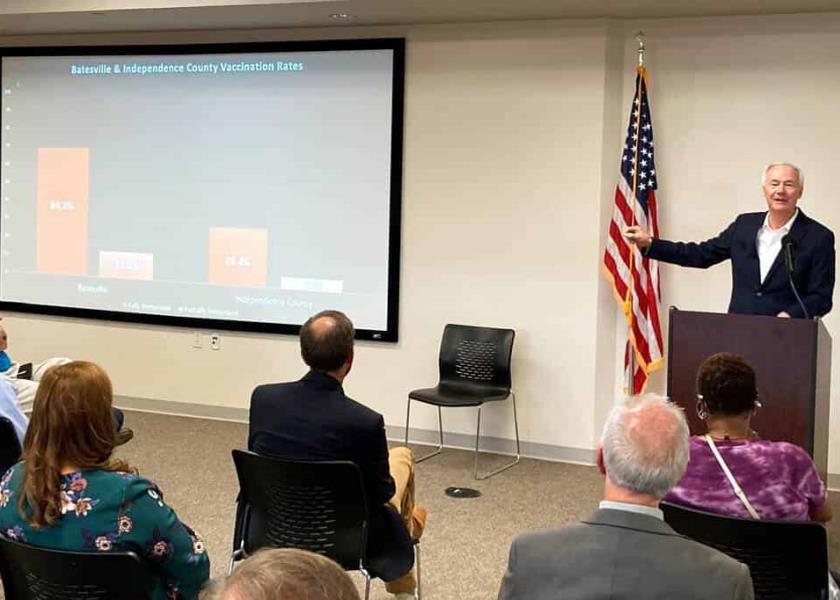 El gobernador de Arkansas, Asa Hutchinson, muestra gráficos sobre las tasas de vacunación en una reunión con residentes en Batesville, Arkansas. (AP Foto/Andrew DeMillo)