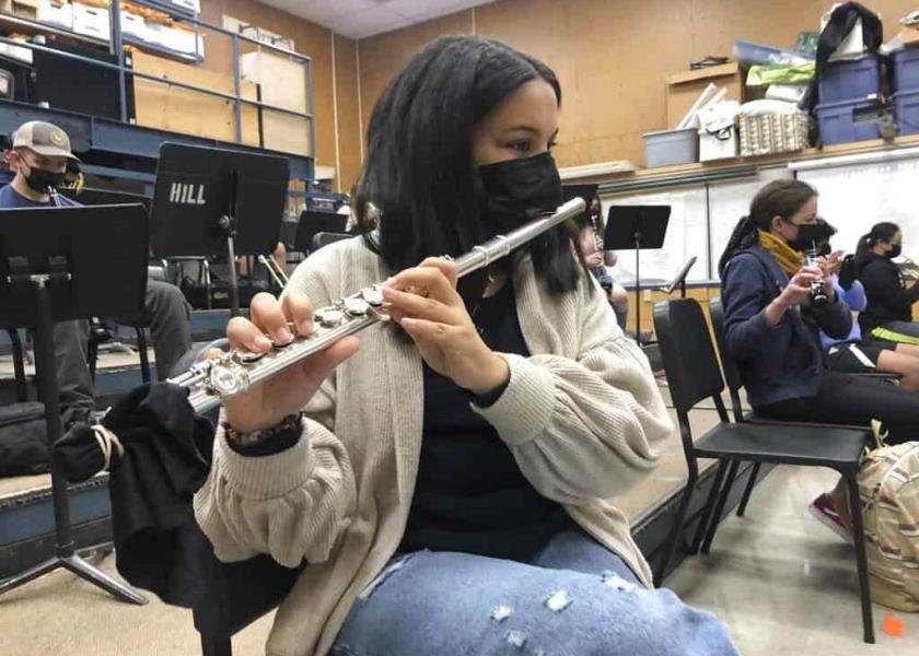 Estudiante toca la flauta mientras usa cubrebocas durante una clase de música en California. (AP Foto/Haven Daily)