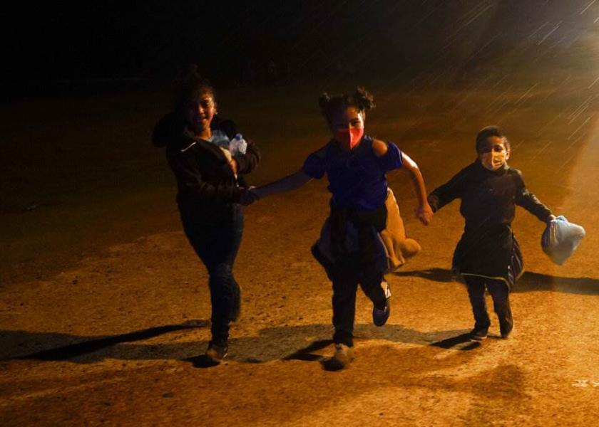 Foto de archivo: Tres niños inmigrantes corren bajo la lluvia tras entregarse a las autoridades de EEUU, luego de cruzar la frontera entre Estados Unidos y México en Roma, Texas. (AP Foto/Gregory Bull)