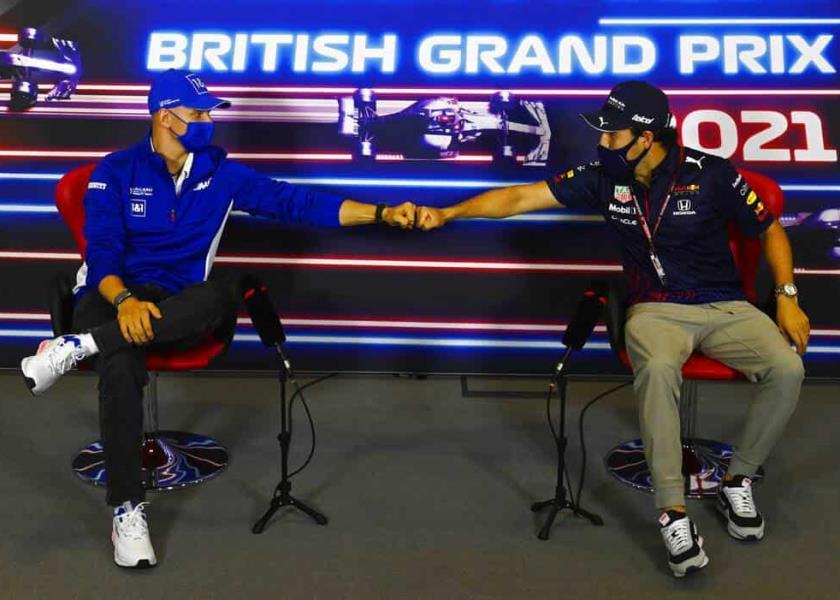 Foto de archivo de los pilotos Mick Schumacher (izquierda) y Sergio Pérez, quienes chocan los puños durante una conferencia de prensa en Silverstone, Inglaterra. (Mark Sutton, Pool Photo vía AP, Archivo)