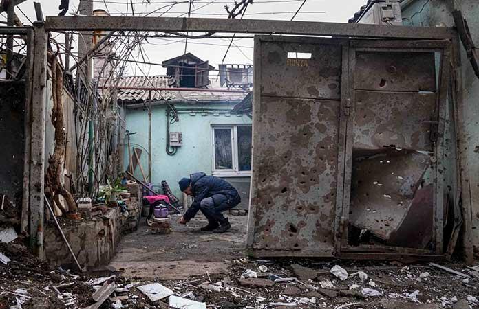 Un hombre enciende fuego en las ruinas de una casa en Mariúpol, Ucrania / Foto: AP