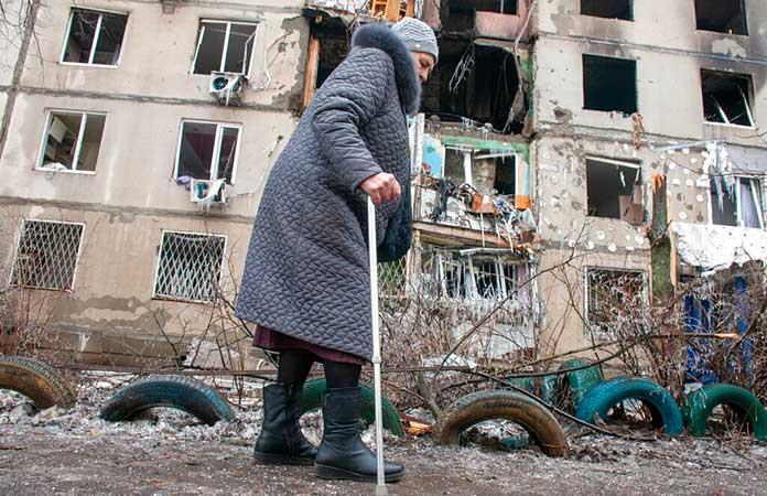 Una mujer pasa junto a un edificio de apartamentos alcanzado por un bombardeo en Kharkiv, Ucrania / Foto: AP