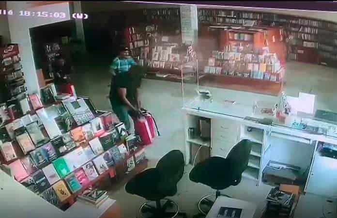 Personal universitario en el interior de la librería, preparando los extintores el 8 de marzo.
