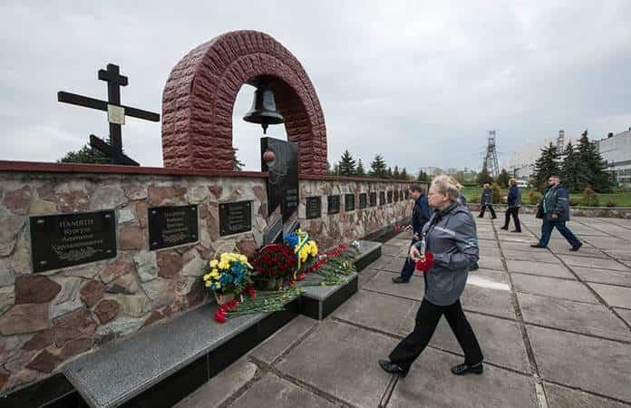 Trabajadores de la planta nuclear de Chernóbil depositan flores en un monumento a las víctimas de la tragedia / Foto: AP