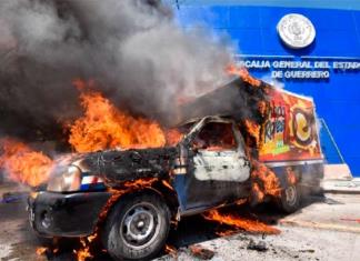 Normalistas lanzan cohetones y queman camioneta en fiscalía