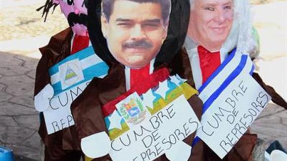 Migrantes en México queman piñatas de presidentes en protesta contra la cumbre migratoria