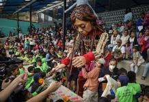Niños migrantes reciben a la marioneta Amal en Tijuana