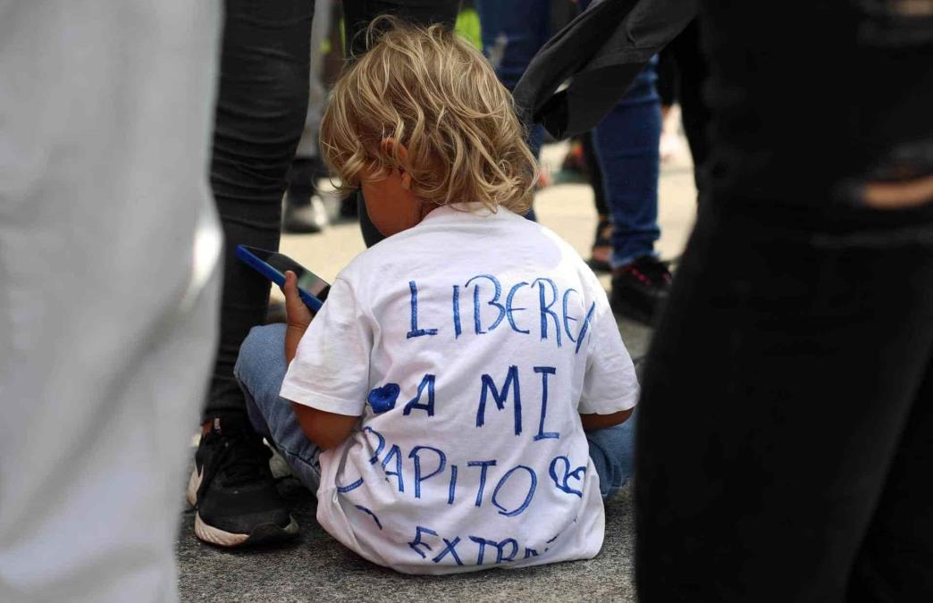 Un niño con una camisa que dice liberen a mi papito participa en una protestan hoy, en una calle de San Salvador