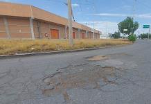 Baches afectan el paso en el Eje 128 de Zona Industrial