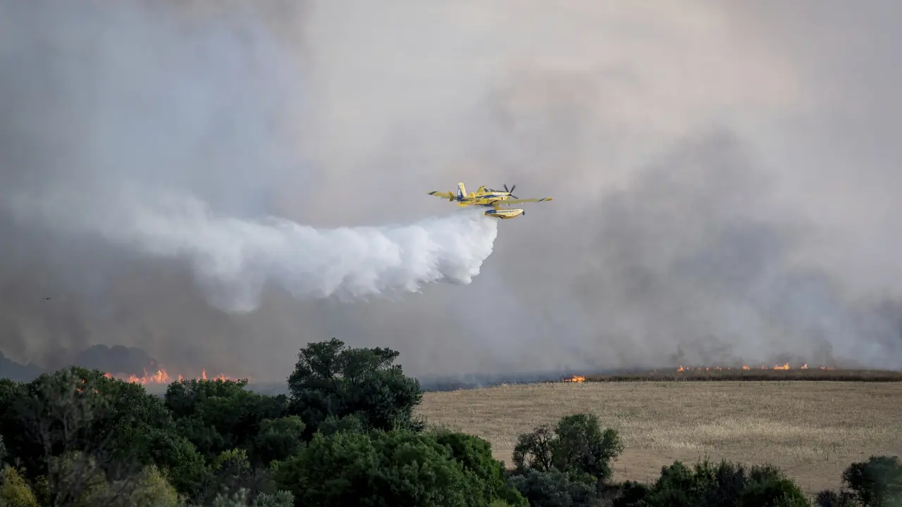Un incendio forestal descontrolado envía una nube de humo sobre la ciudad