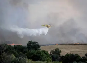 Un incendio forestal descontrolado envía una nube de humo sobre la ciudad