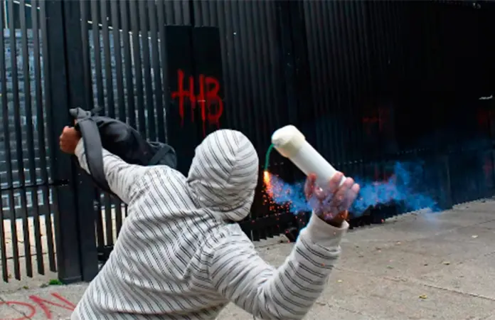 Protesta de normalistas de Ayotzinapa con lanzamiento de petardos