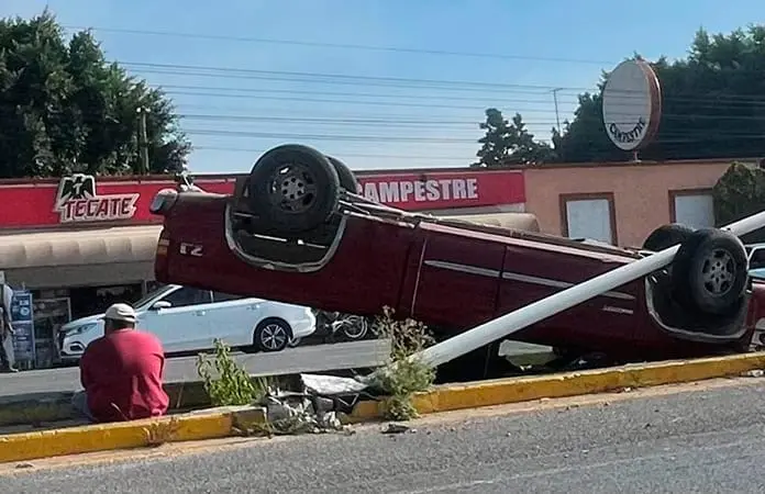 Rauda camioneta derriba un poste y acaba volcada