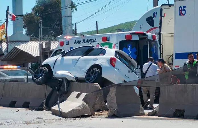 Automóvil se trepa en contención del bulevar