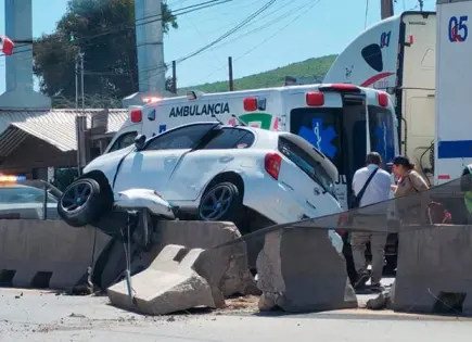 Automóvil se trepa en contención del bulevar