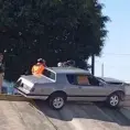 Carro se trepa en contención de puente