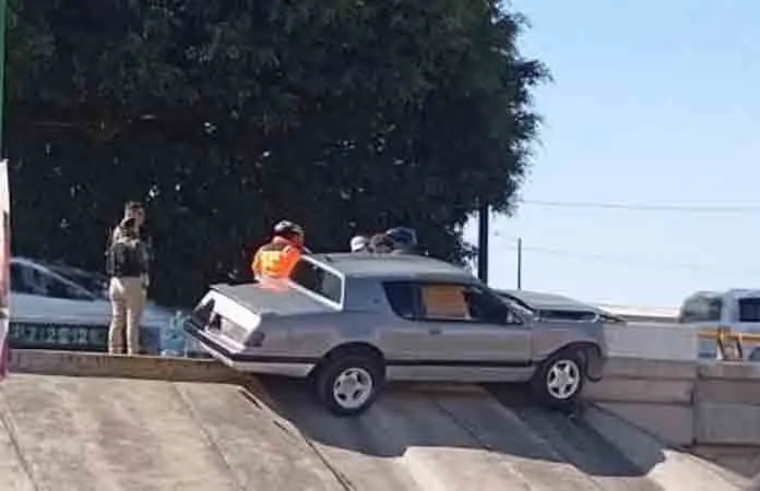 Carro se trepa en contención de puente