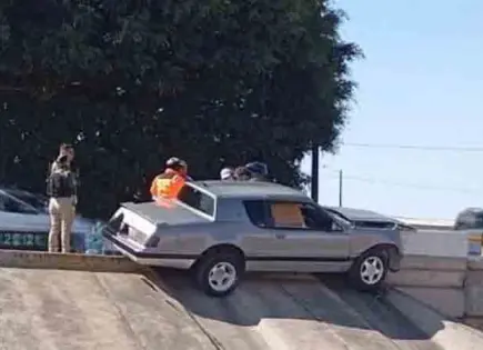 Carro se trepa en contención de puente