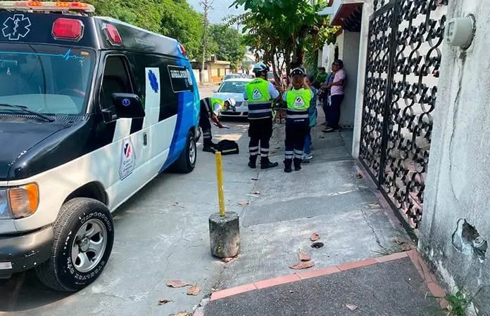Mujer se recarga en el portón de una casa y la muerde un perro