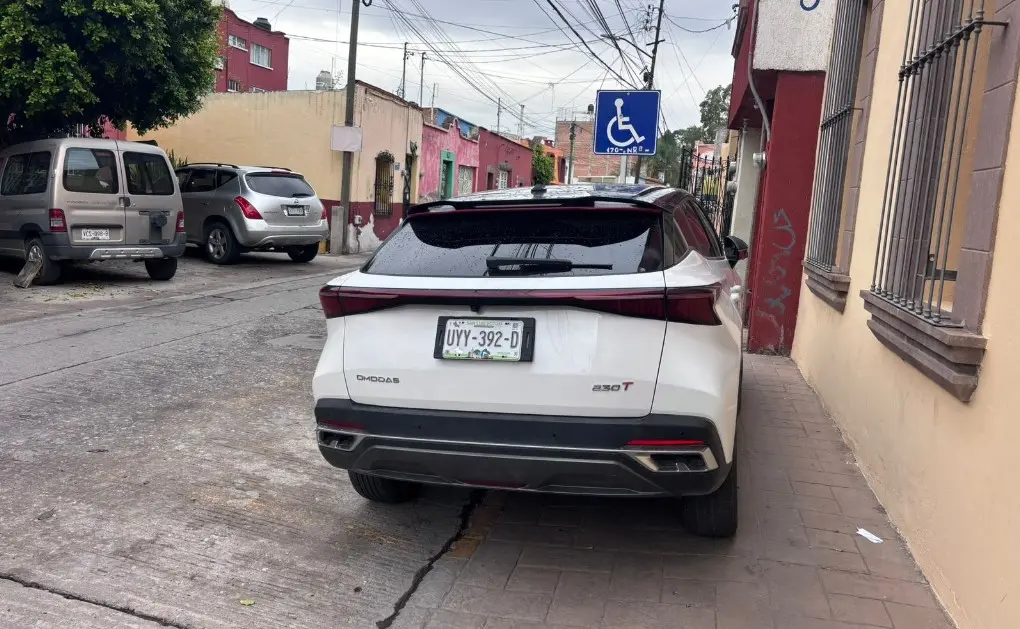 Camioneta invade banqueta y cajón para discapacitados