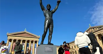 Aficionados brasile&ntilde;os respetan estatua Rocky en Filadelfia durante Mundial