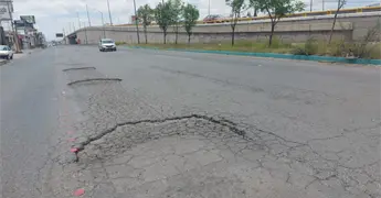 Reaparecen baches reci&eacute;n reparados en lateral de la 57