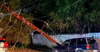 Poste de luz colapsa encima de camioneta